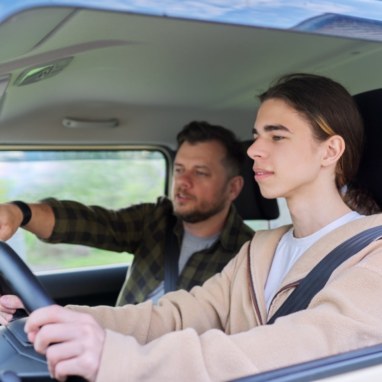 Father teaching his teenage son to drive