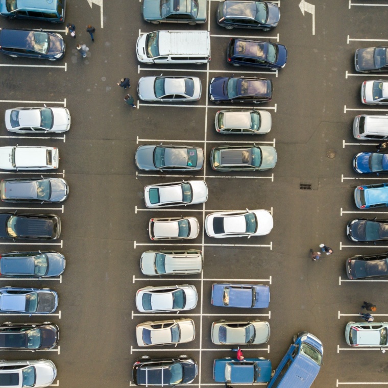 Top view of many cars parked on a parking lot.