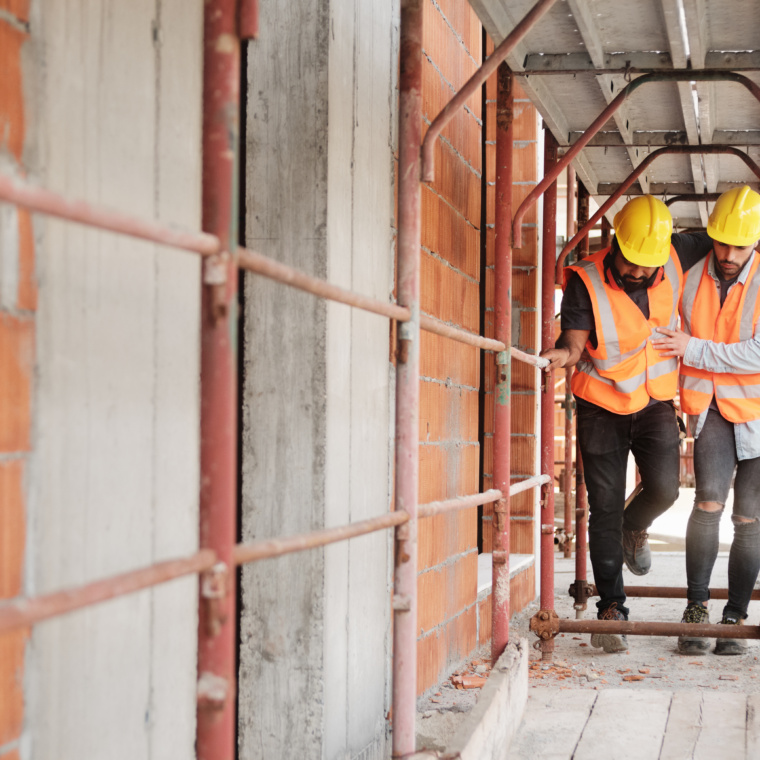 Manual Worker Helping Injured Colleague In Construction Site