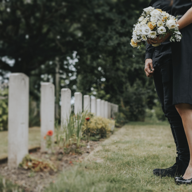 Couple standing together by a gravestone