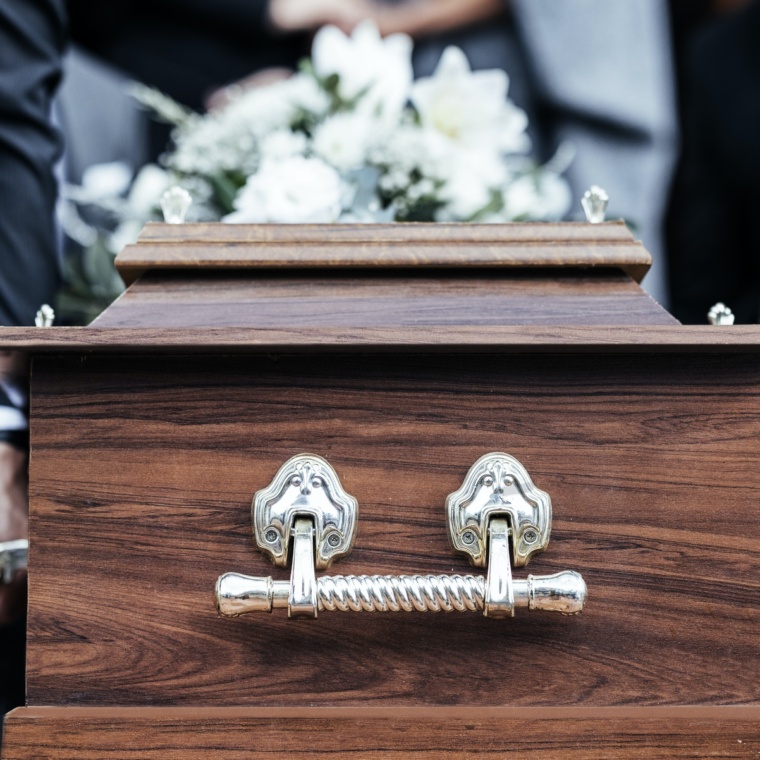 Coffin, people and funeral with death, grief and service with family carry casket to grave outdoor.